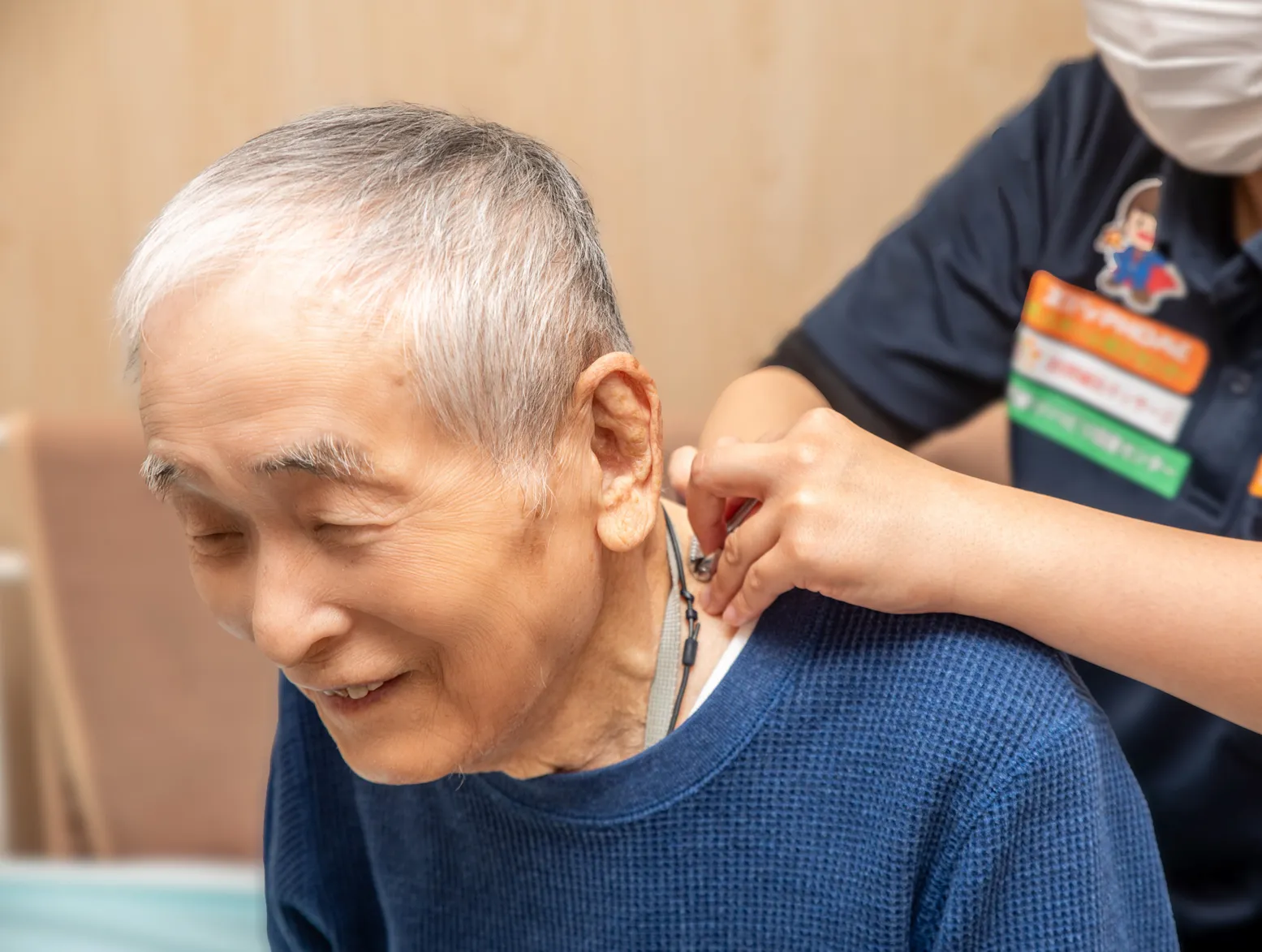 豊橋の訪問マッサージで首や肩の痛みに施術を行うスタッフ