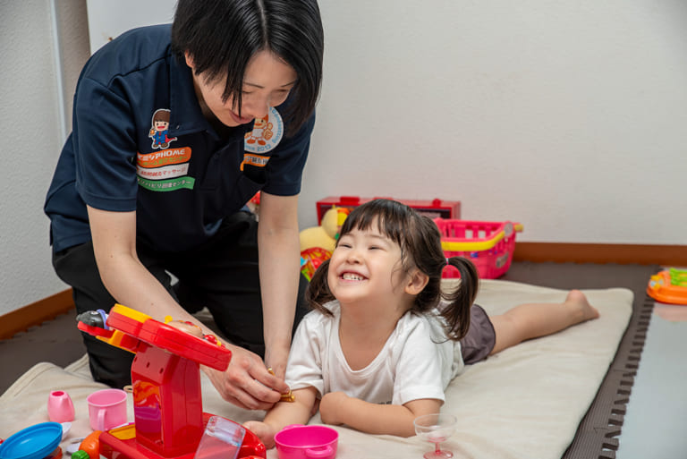 訪問マッサージを受ける女の子が笑顔で楽しそうに遊ぶ様子